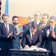 Brazilian President Fernando Collor de Mello, center, is applauded by U.N. Secretary General Boutros Boutros-Ghali, right, as he signs the framework convention on climate change at the United Nations Conference on Environment and Development (UNCED), known as the Earth Summit, in Rio de Janeiro, Brazil, Thursday, June 4, 1992.